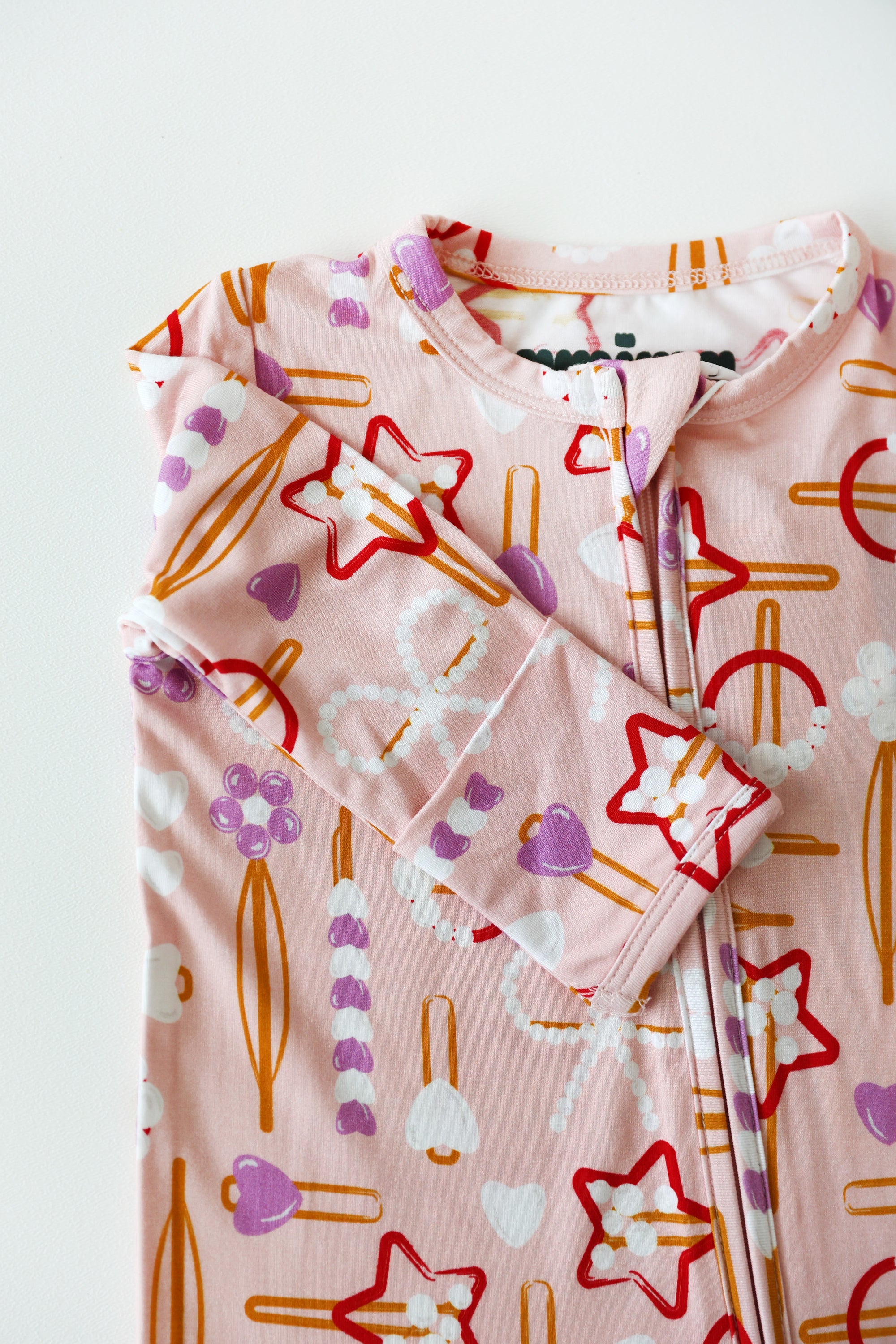 Baby outfit with pink patterned fabric on a white background