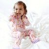 Child wearing pajamas with star patterns on a white bed