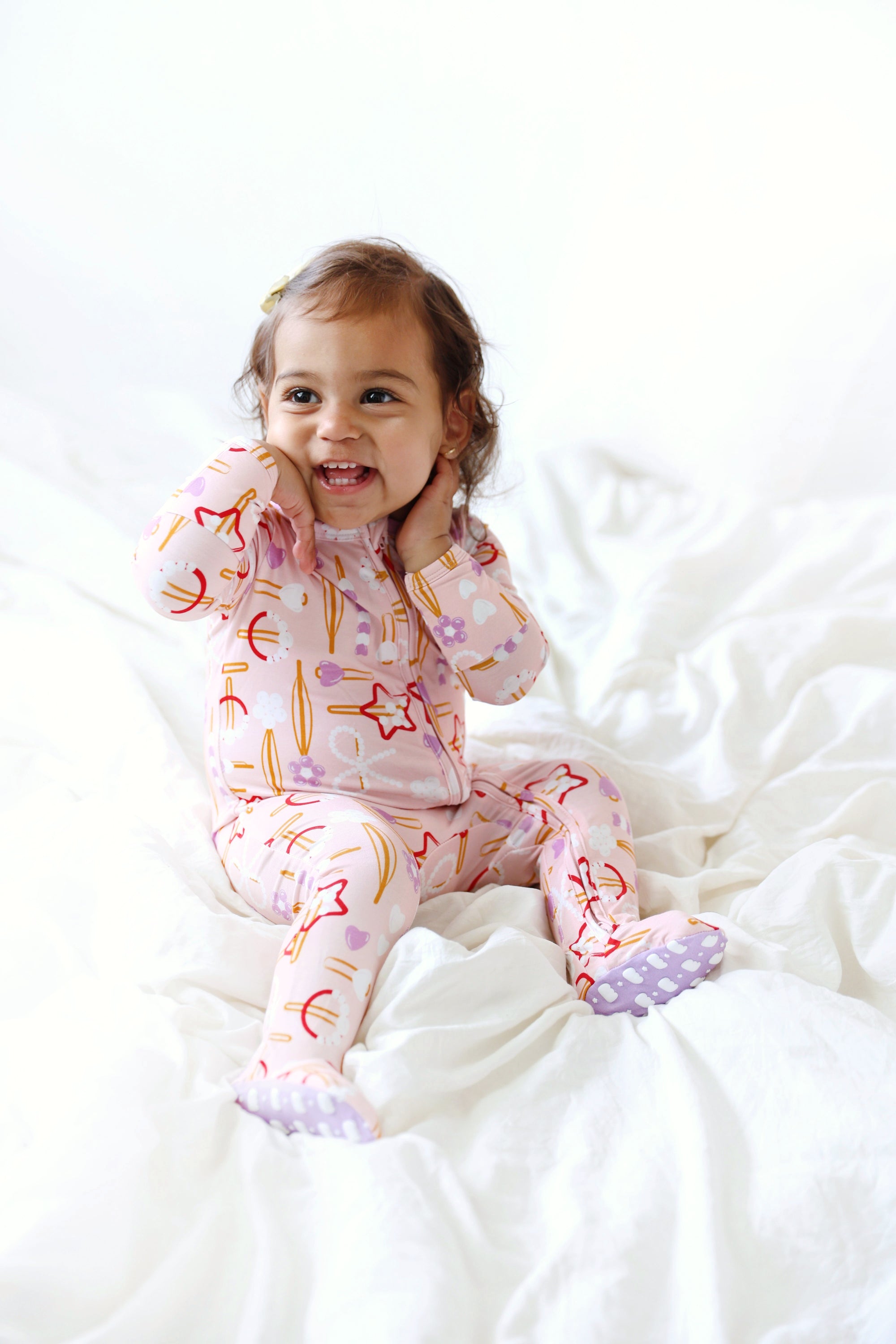 Child wearing pajamas with star patterns on a white bed