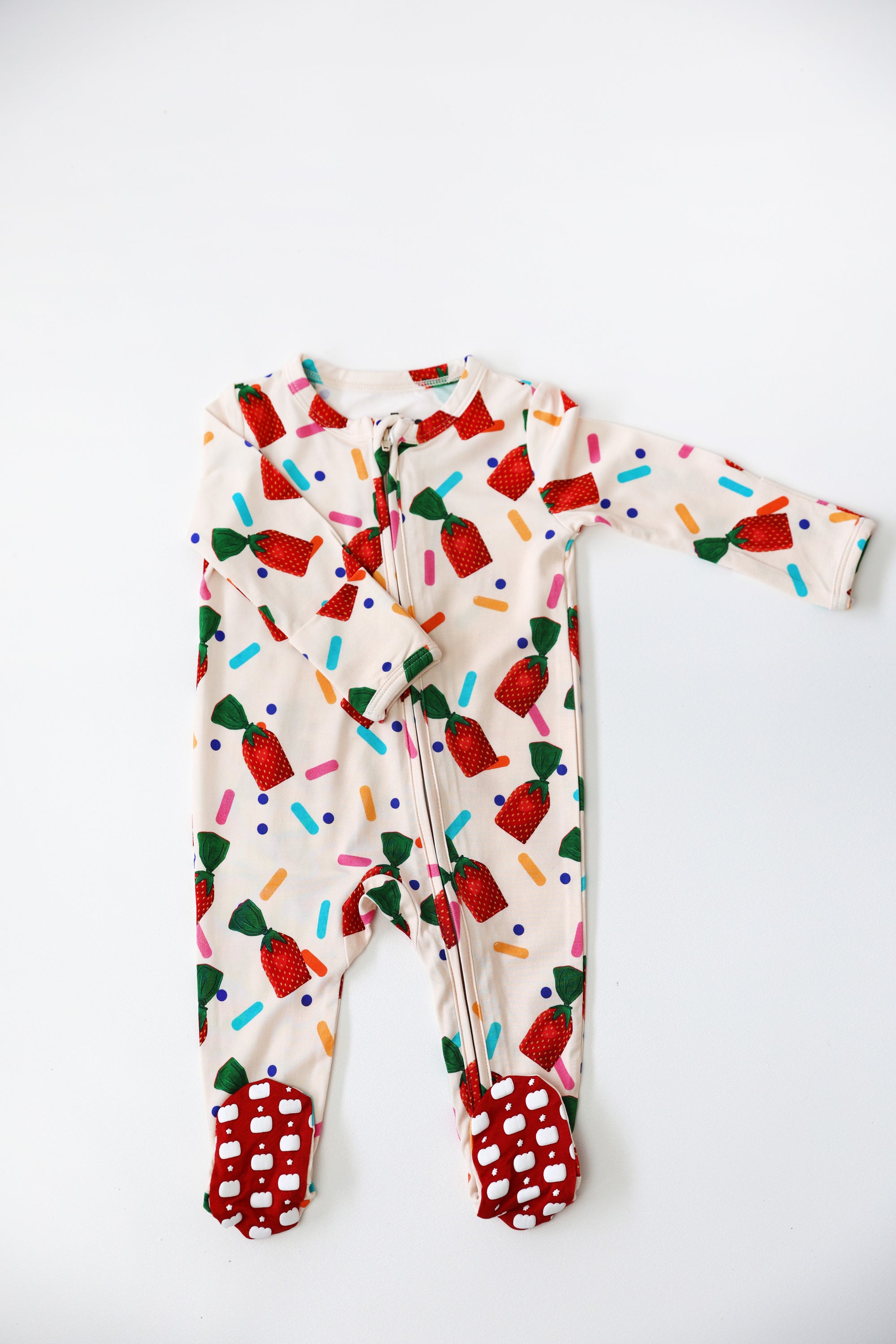 Colorful baby onesie with candy-themed design on a white background