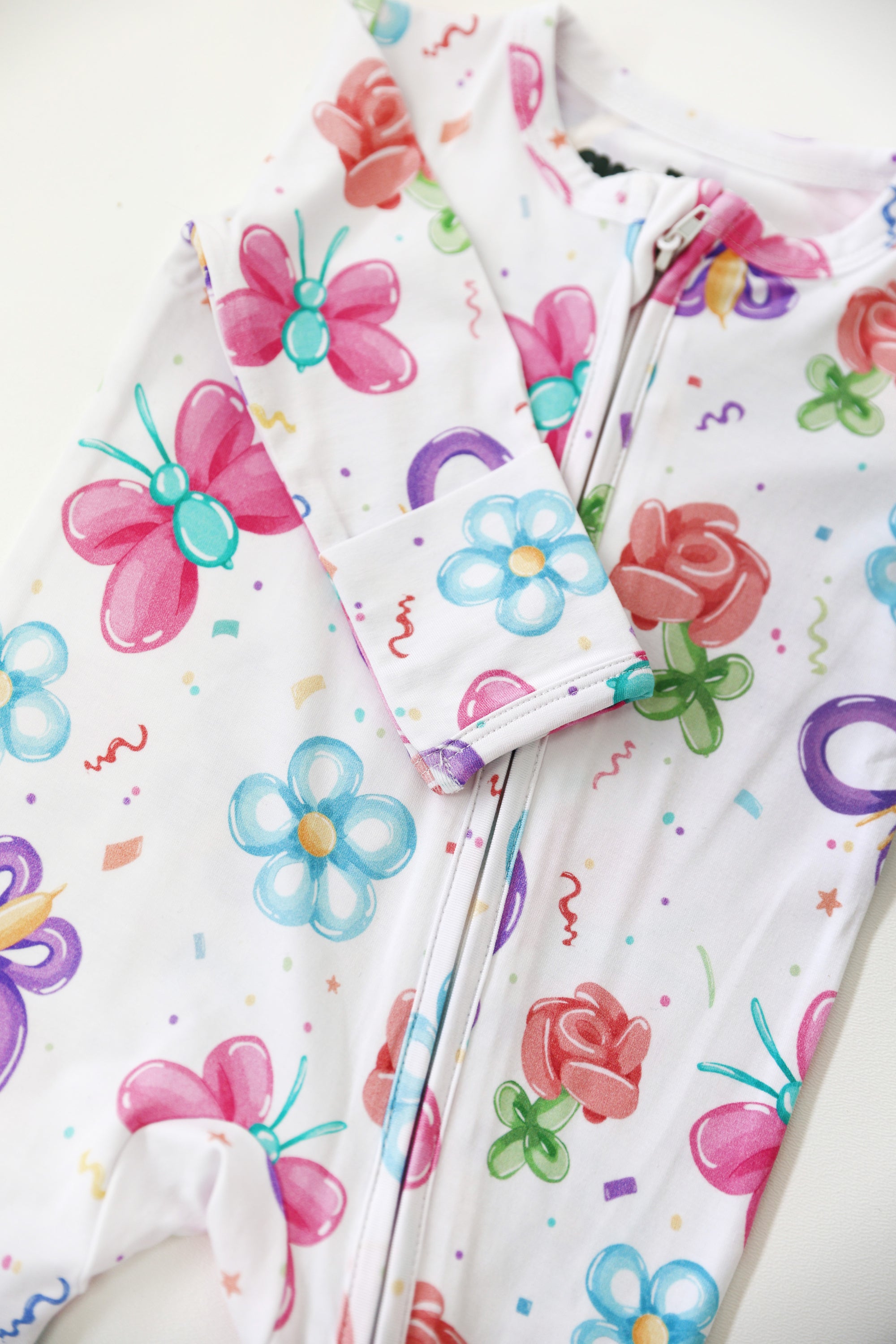 Children's outfit with colorful butterfly and flower patterns on a white background