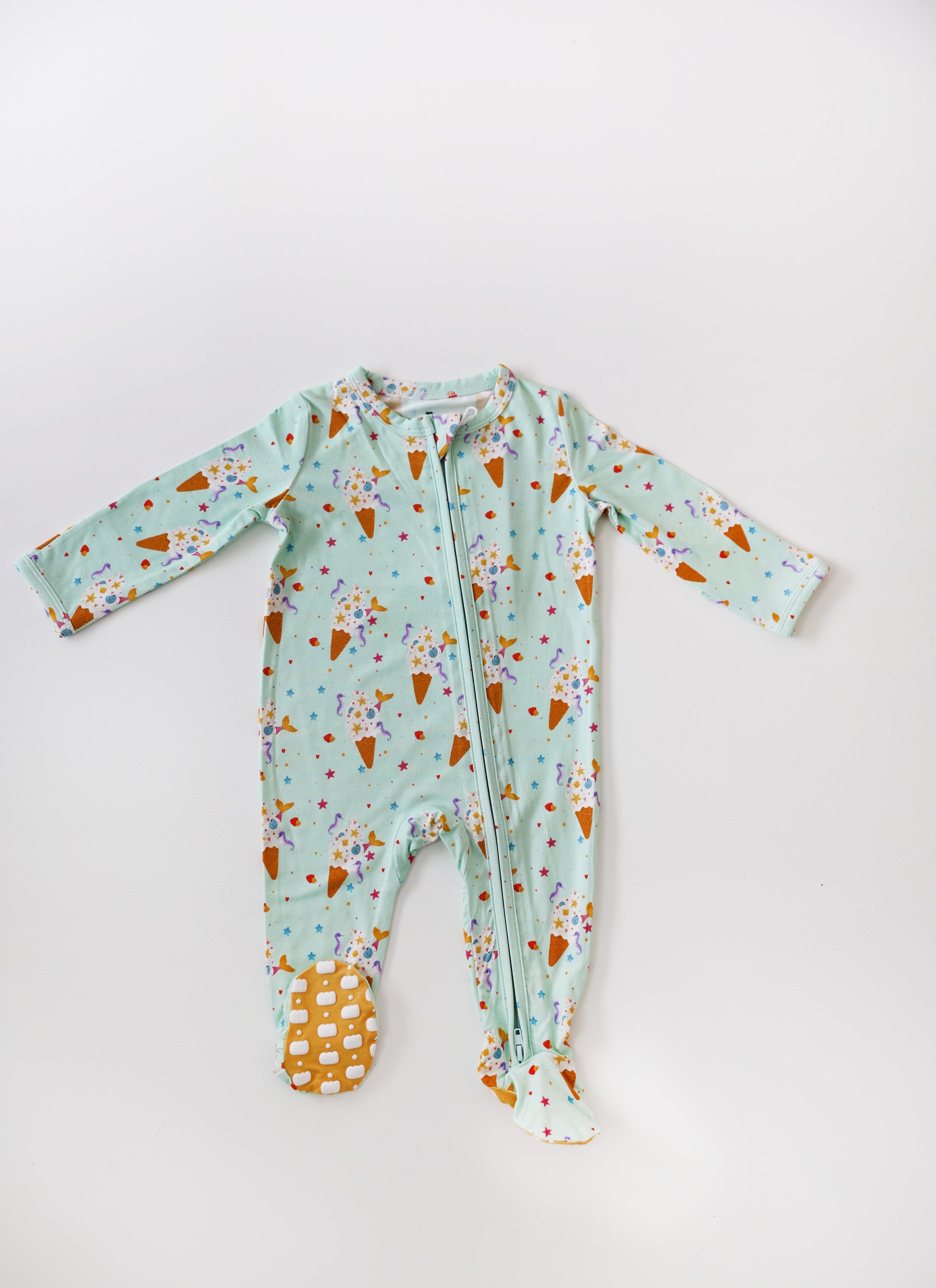 Baby onesie with ice cream cone pattern on a light blue background