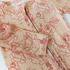 Beige fabric with red floral pattern on a white background