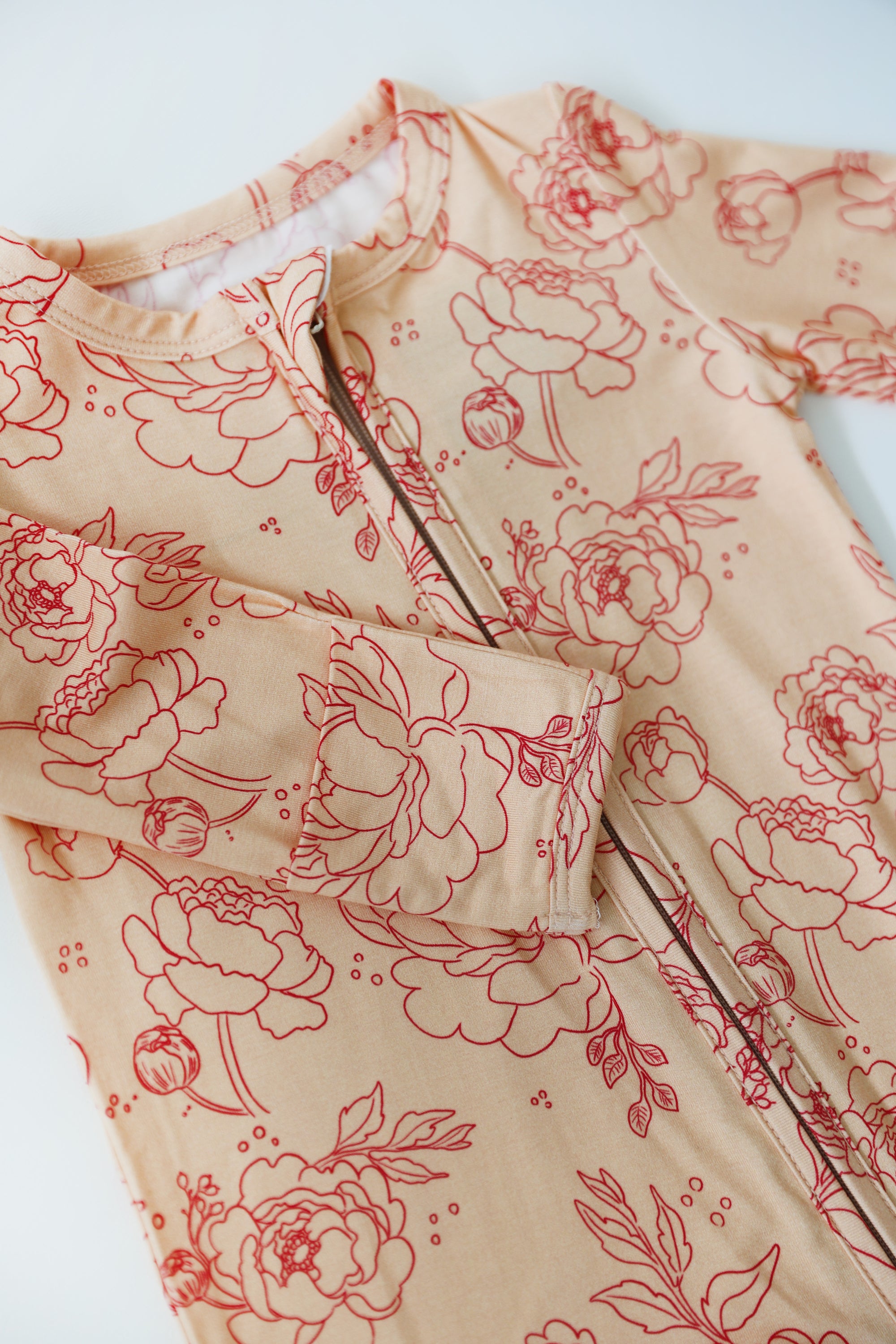 Beige fabric with red floral pattern on a white background