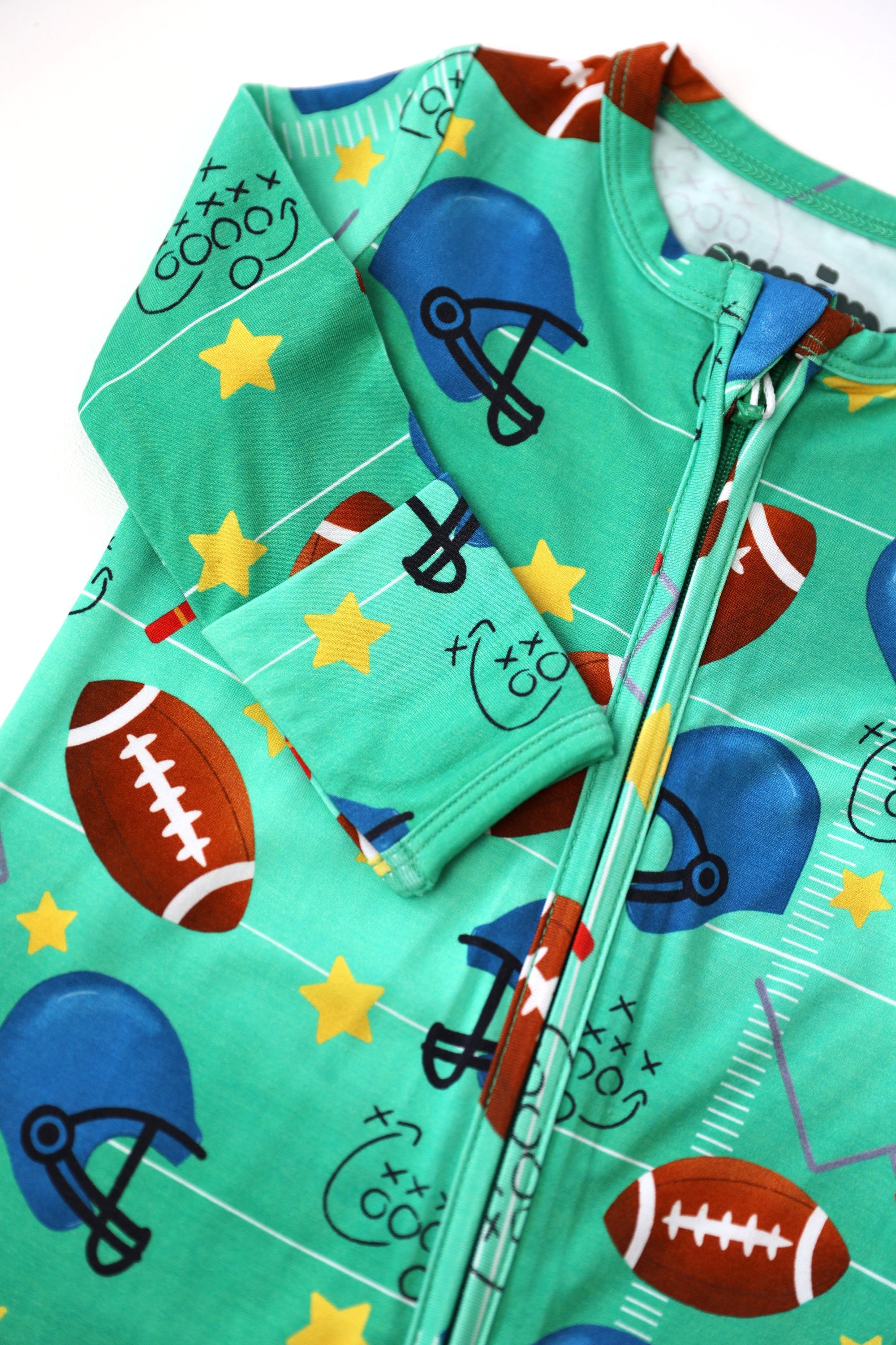 Children's green outfit with sports-themed design on a white background