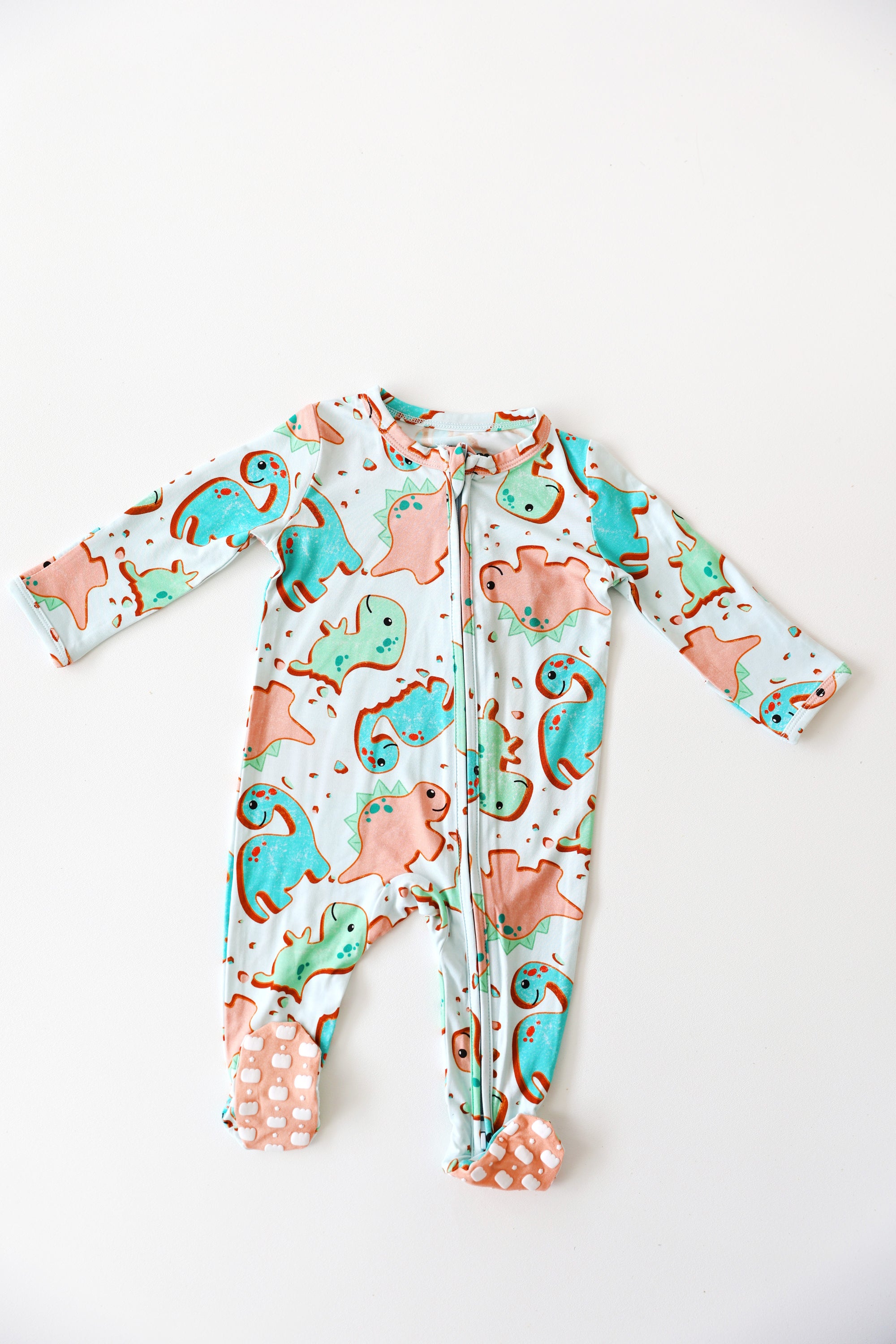 Baby onesie with dinosaur pattern on a white background